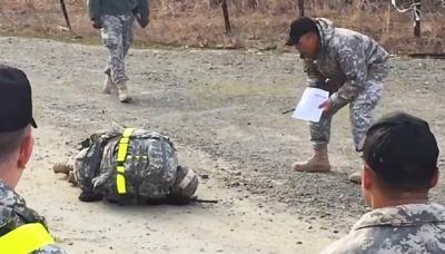 a collapsed exhausted soldier with superior yelling next to him